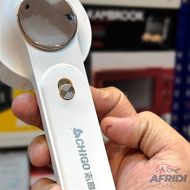 White handheld portable fan with a metallic gold and silver circular accent.