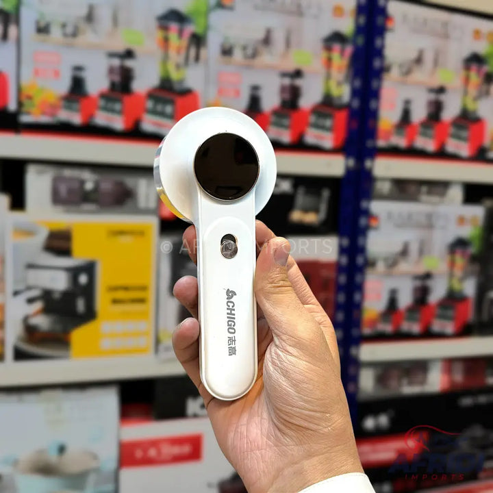 White portable lint remover held in a hand.