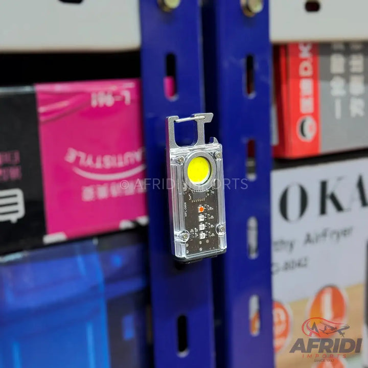 A clear plastic mini LED flashlight with a carabiner clip.