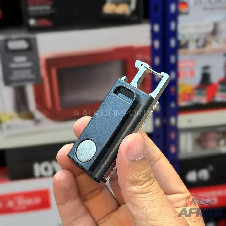 A black multi-tool with a silver carabiner clip and a circular button.