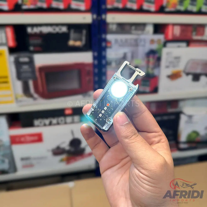 A compact, transparent electronic device with a bright, circular light and exposed circuitry, designed for portability.