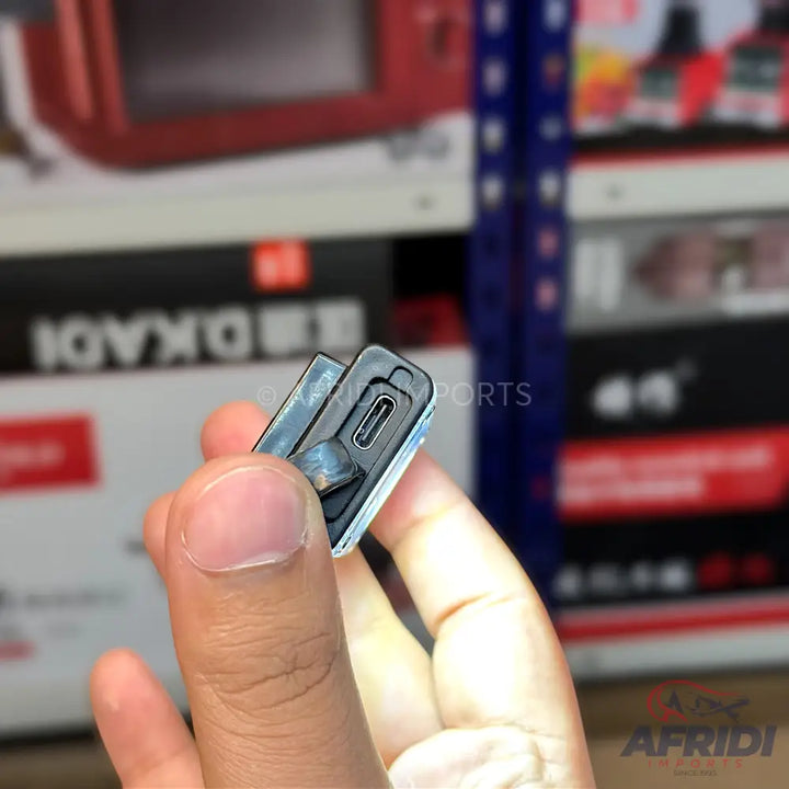 A black electronic device with a USB-C port, held between two fingers.