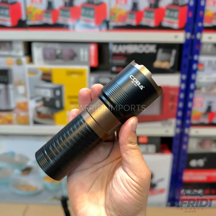 A black and gold tactical flashlight with a textured grip.