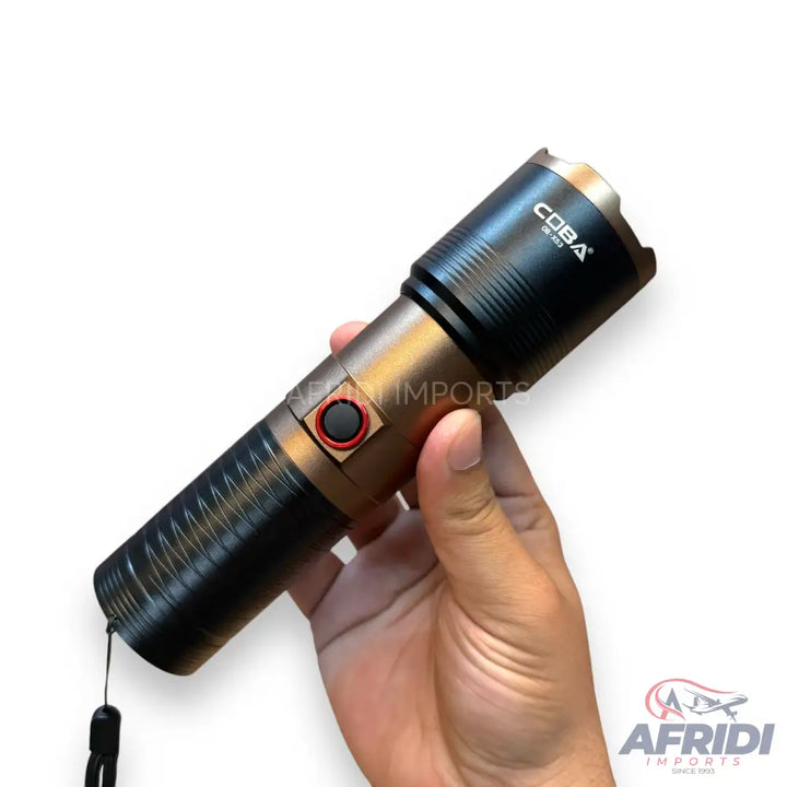A black and bronze tactical flashlight with a wrist strap.