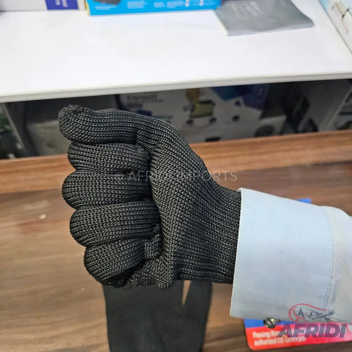 Black, cut-resistant glove on a hand.