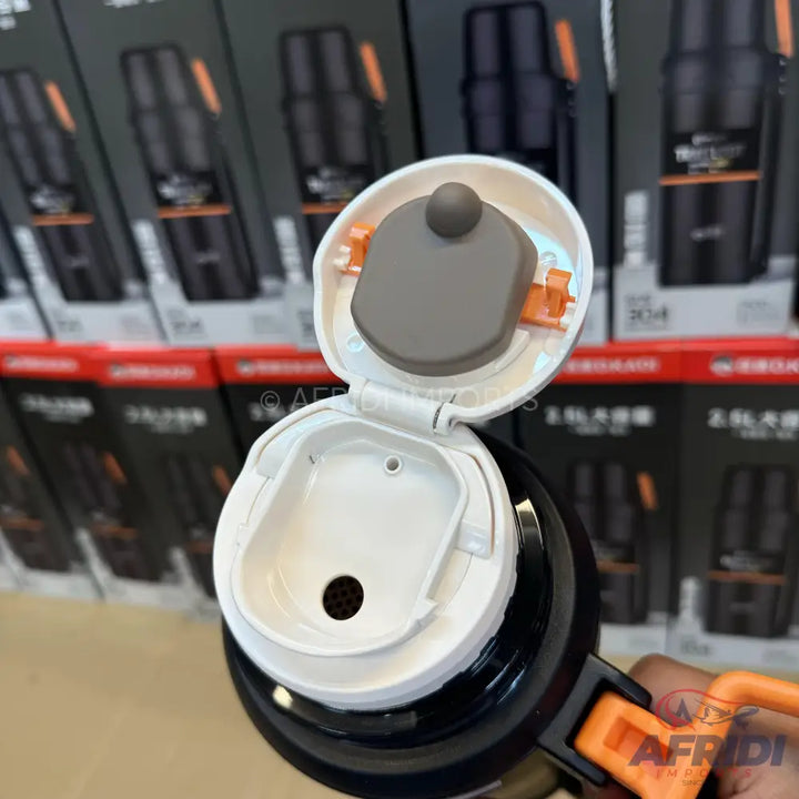 Black insulated travel mug with an open white lid and orange accents.