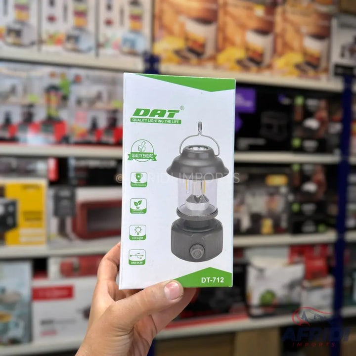 A boxed camping lantern with a hanging handle and a dial on the base.