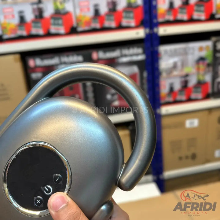 A metallic gray electric kettle with a curved handle and a circular control panel featuring power and temperature buttons.