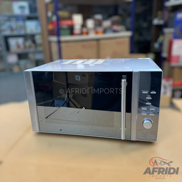 Silver-colored microwave oven with a reflective glass door and control panel.