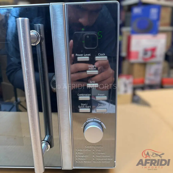 Modern microwave oven with a reflective black door, silver handle, and a control panel featuring buttons and a dial.