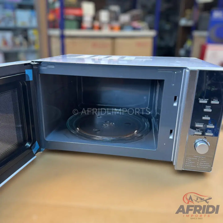 A silver and black microwave oven with its door open, revealing the interior and a glass turntable.