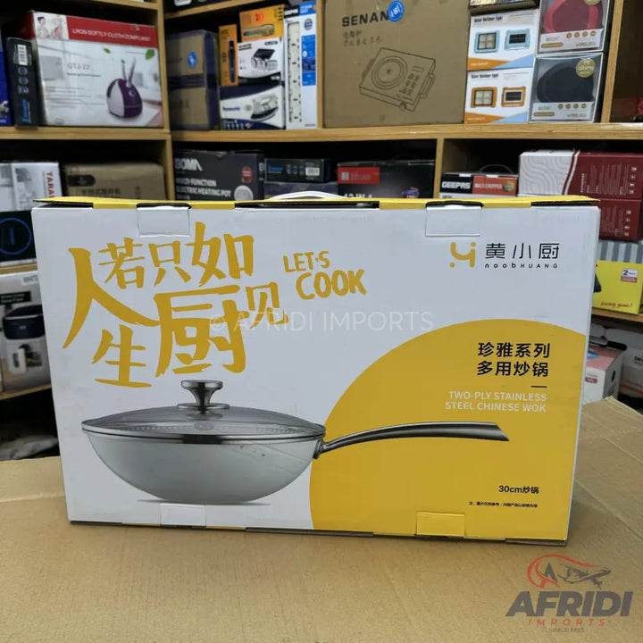 A boxed stainless steel Chinese wok with a glass lid.