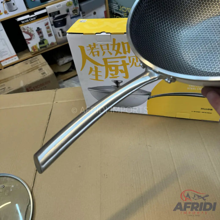 Stainless steel wok with a honeycomb non-stick surface and a long handle.