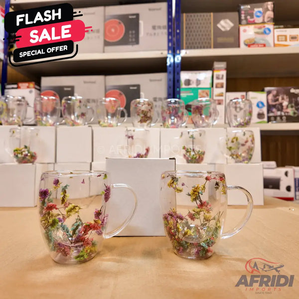 Clear glass mugs with colorful dried flowers embedded in their double walls.