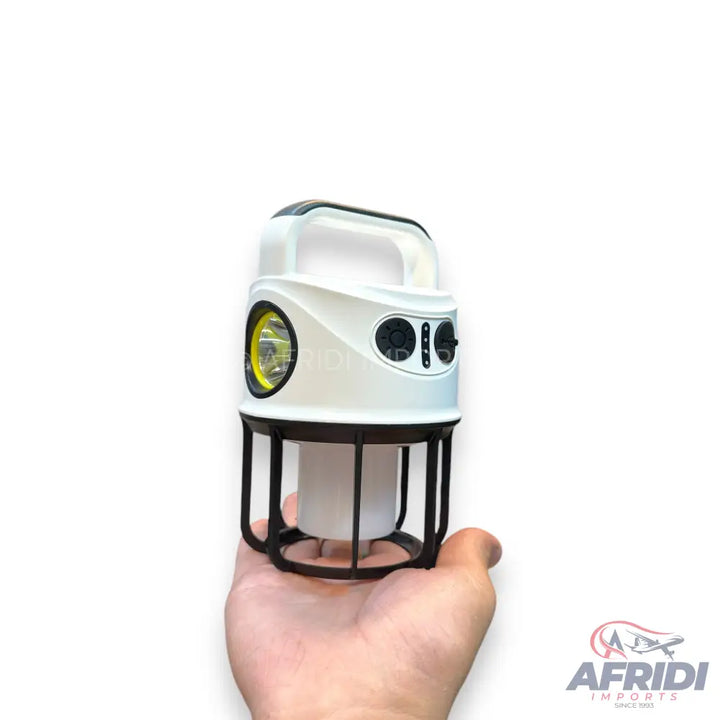 A white and black portable lantern with a spotlight, side light, and a handle.