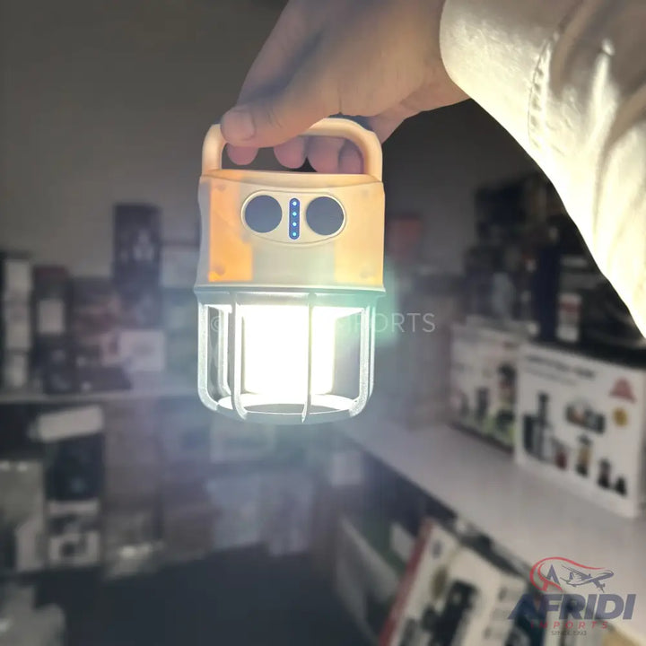 A bright, portable camping lantern with a top handle and visible battery indicator lights.