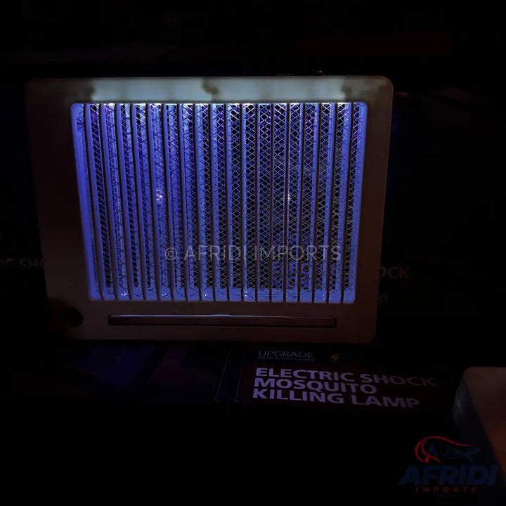 An electric mosquito killing lamp with a purple UV light and a protective grid.