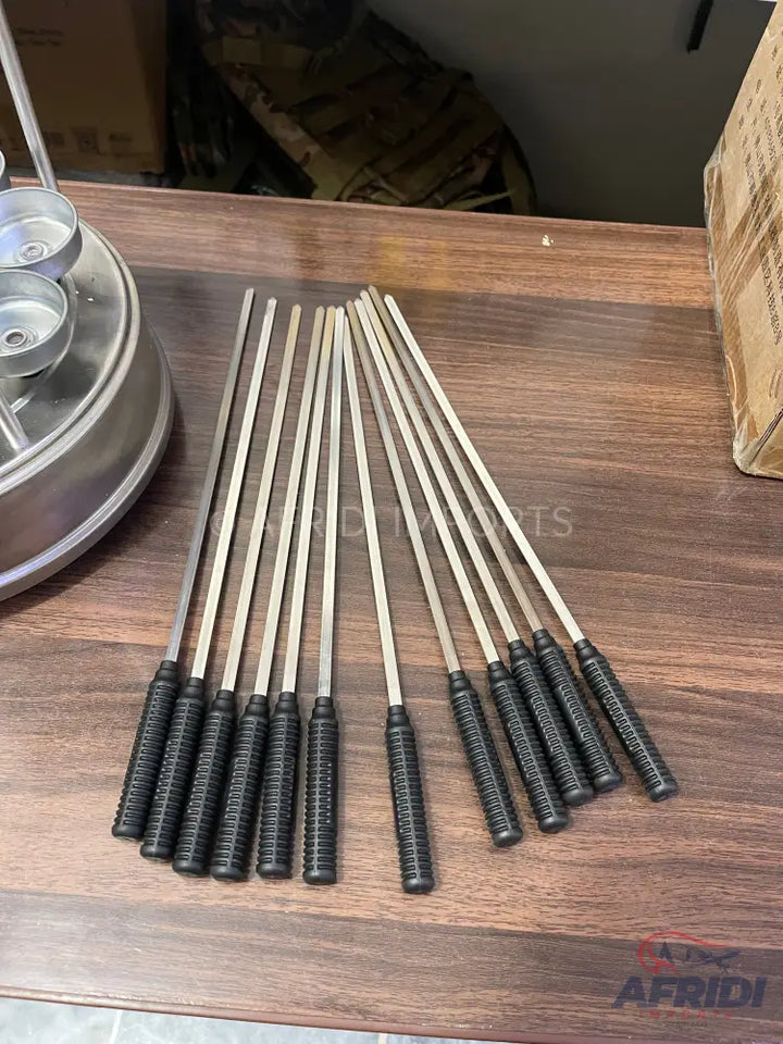 A set of twelve metal skewers with black, textured handles, ideal for grilling.