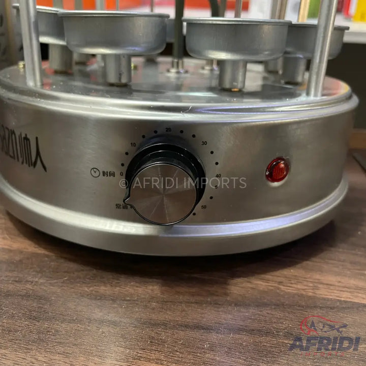A stainless steel automatic rotating skewer grill with a timer dial and power button.