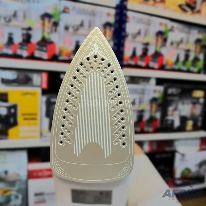 Soleplate of a steam iron with numerous holes and textured channels.