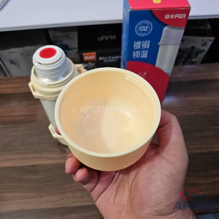 A beige thermos with a removable cup.