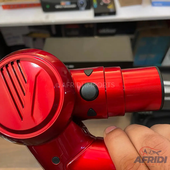 Glossy red handheld vacuum cleaner with an ergonomic grip.