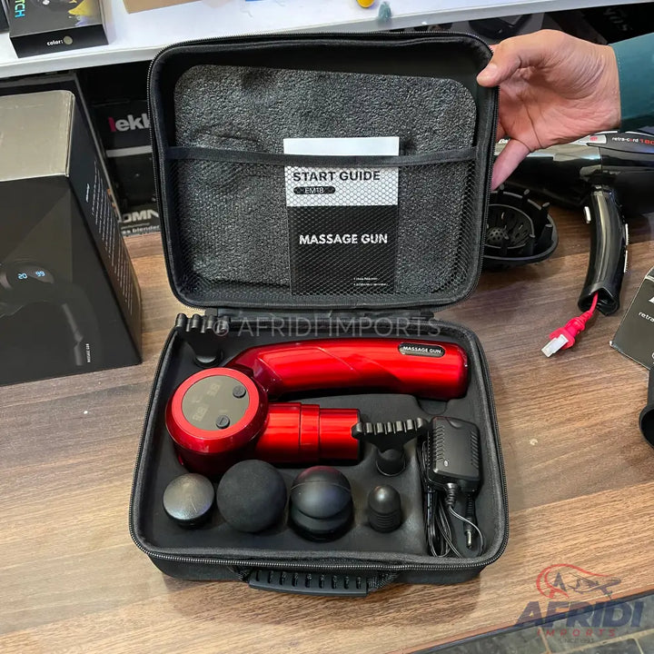Red massage gun kit with multiple interchangeable heads and a charger in a black carrying case.