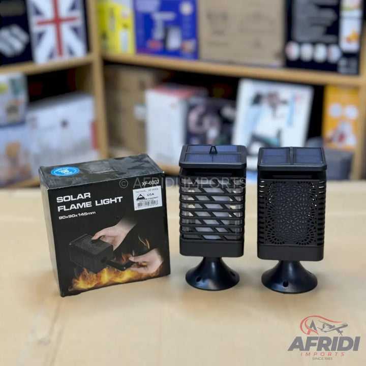 Two black solar flame lights with one in its packaging.
