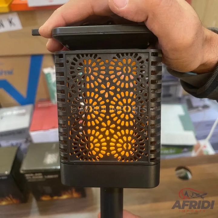A solar-powered outdoor garden torch with a flickering flame effect.