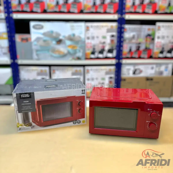 A red microwave oven, still in its packaging, with another identical red microwave oven next to it.