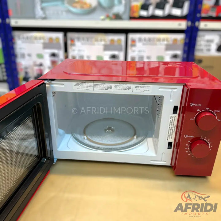 Red microwave oven with its door open revealing a glass turntable.