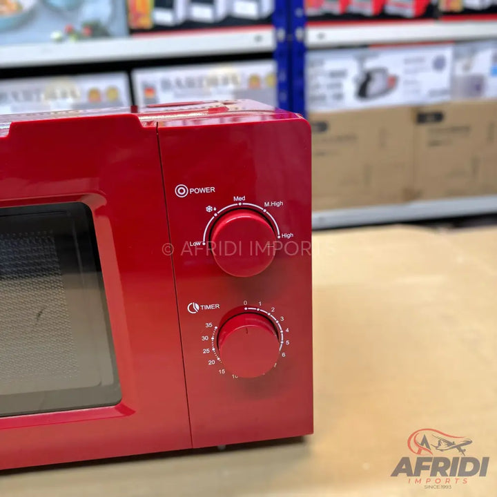 Red microwave oven with two control knobs.
