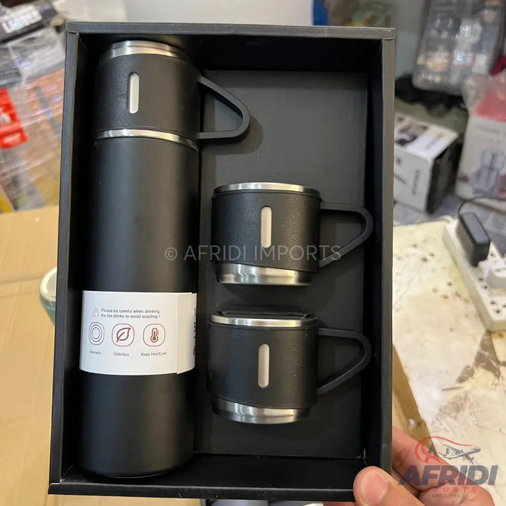 A black insulated thermos bottle with two matching mugs, presented in a gift box.