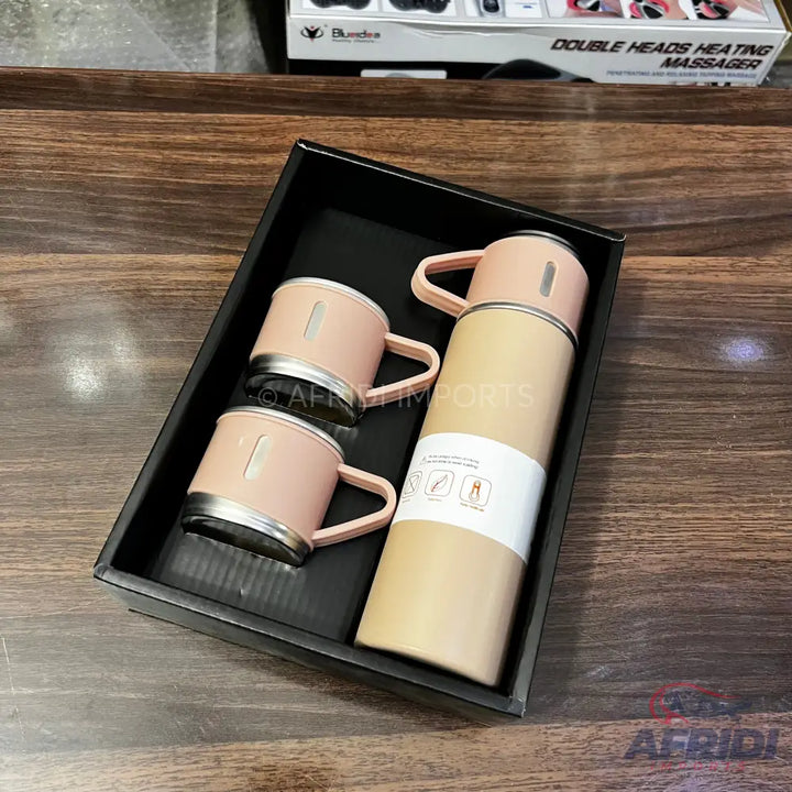 A gift set containing a pale pink insulated thermos and two matching mugs with handles.