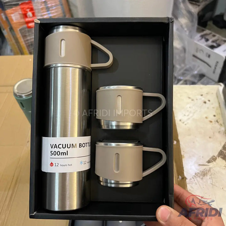A stainless steel vacuum bottle and two matching cups in a gift box.