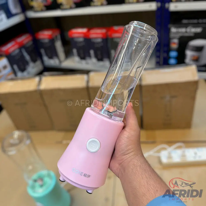 A pink portable blender with a clear mixing cup.