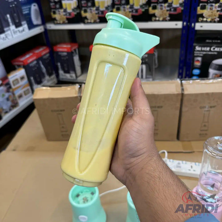 A portable blender with a yellow bottle and a mint green lid.