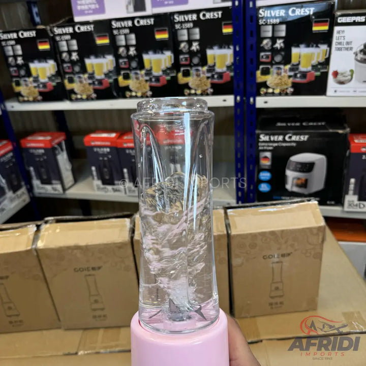 Pink portable blender with a clear cup showing liquid being blended.