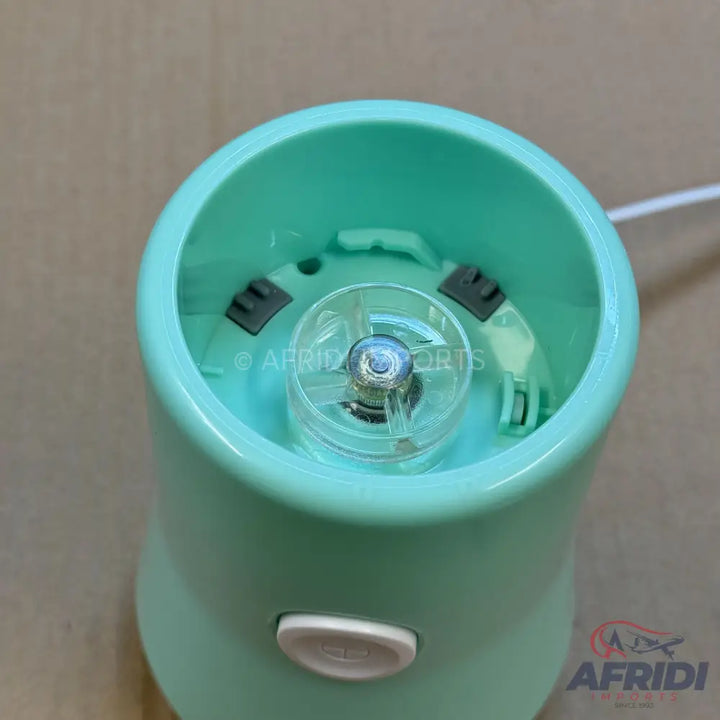An open, light blue portable blender with a visible motor base and power button.