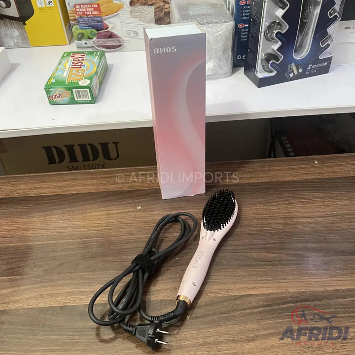 Light pink electric hair straightening brush with black bristles and power cord.