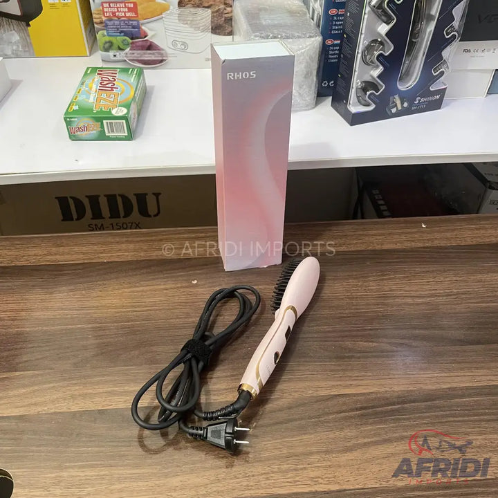 Pink hair straightening brush with a black power cord.