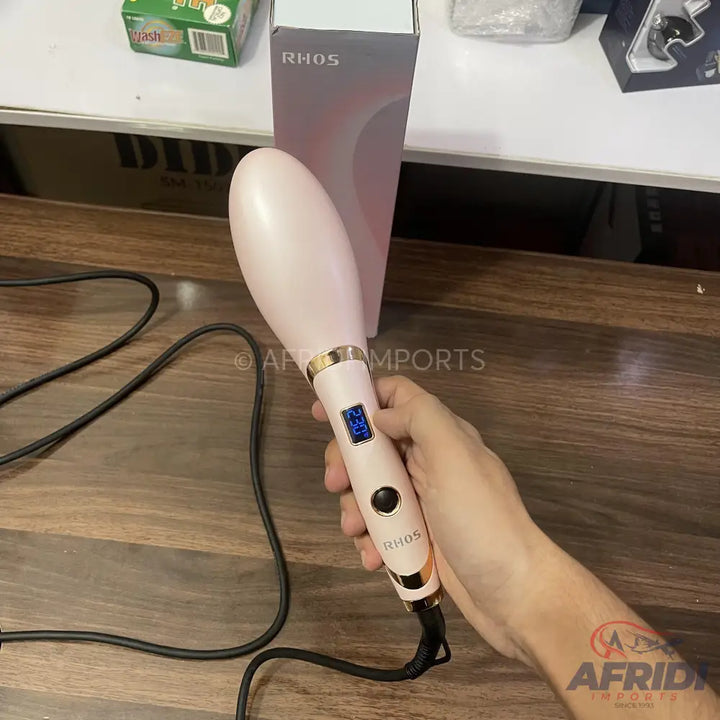 Pink hair straightening brush with a digital temperature display.