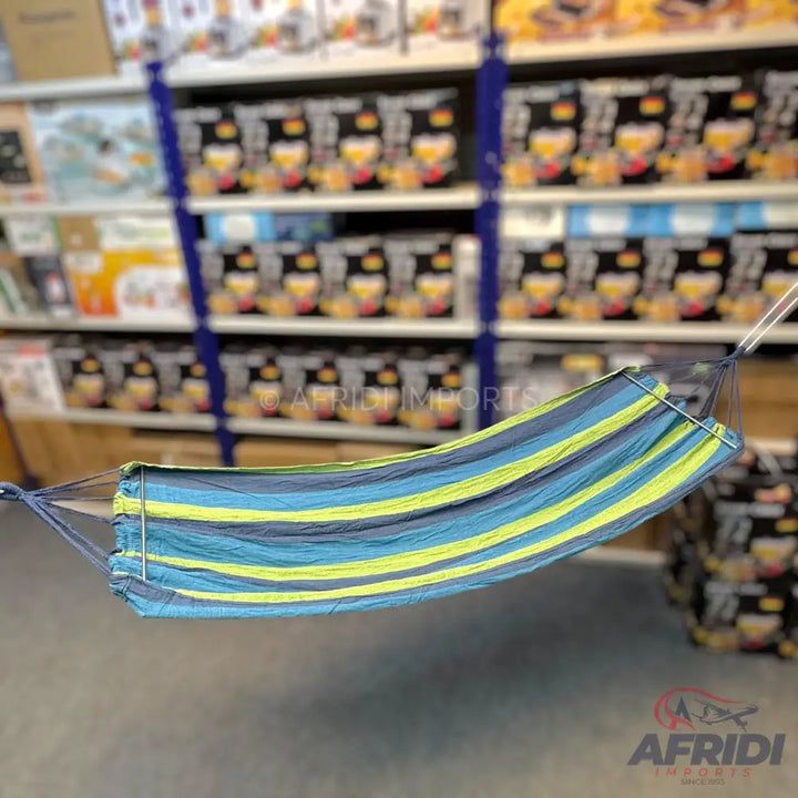 A striped fabric hammock in shades of blue, green, and yellow, designed for relaxation.