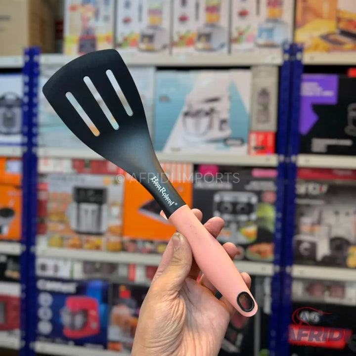 Black slotted spatula with a pink handle.