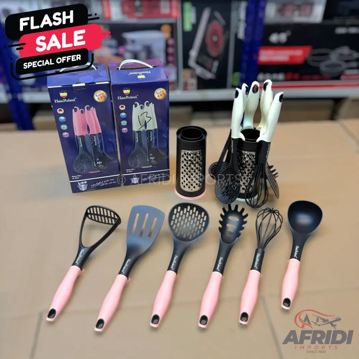 A set of black and pink kitchen utensils, including a masher, spatulas, ladles, and whisks, some packaged and some displayed in holders.