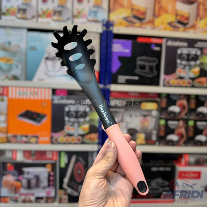 Black and pink silicone pasta server with a serrated edge.