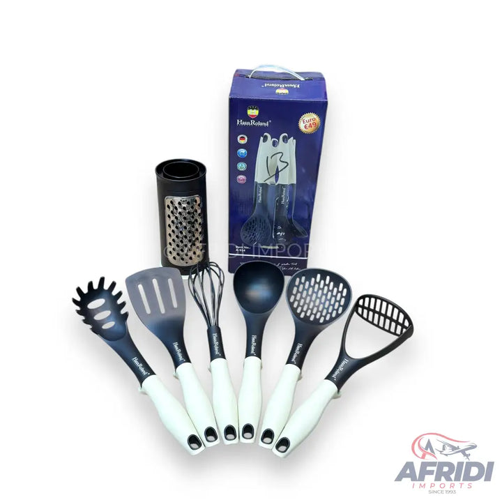 A set of kitchen utensils, including a pasta server, slotted spatula, whisk, ladle, slotted spoon, and potato masher, with white handles and black heads, accompanied by a grater and a storage box.