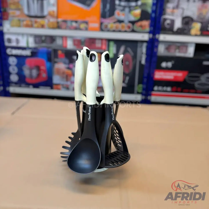 A set of black and cream kitchen utensils on a rotating stand.