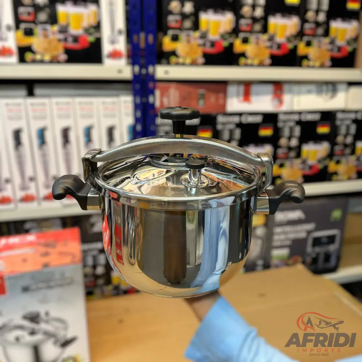 A shiny stainless steel pressure cooker with black handles.