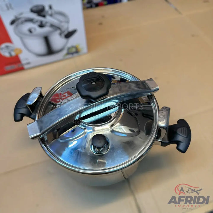 Shiny stainless steel pressure cooker with black handles and lid knobs.